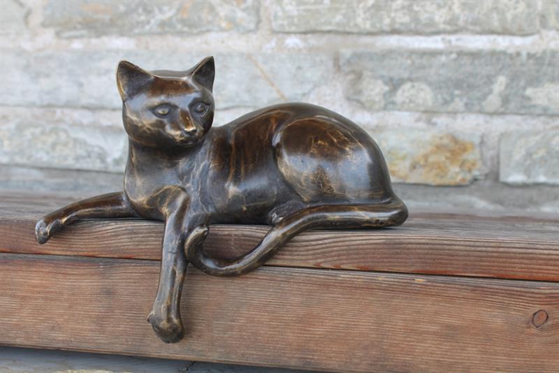 Katze liegend aus Bronzeguß, mit Fuß nach unten hängend